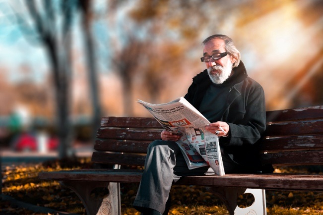 φωτογραφία ενός ηλικιωμένου που διαβάζει εφημερίδα με γυαλιά πρεσβυωπίας